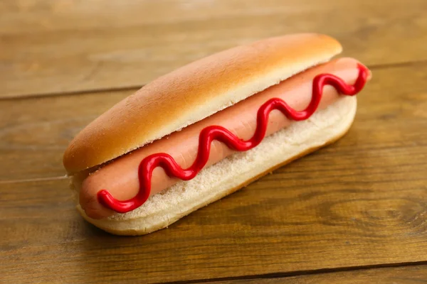 Tasty hot dog on wooden table — Stock Photo, Image