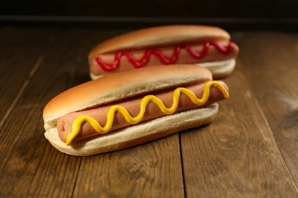 Sabrosos perritos calientes en mesa de madera —  Fotos de Stock