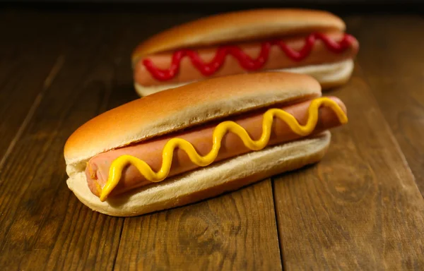 Cachorros-quentes saborosos na mesa de madeira — Fotografia de Stock