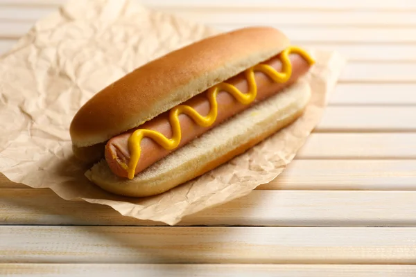 Sabroso perrito caliente en mesa de madera — Foto de Stock