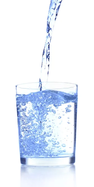 Wlewanie wody do szkła na niebieskim tle — Zdjęcie stockowe