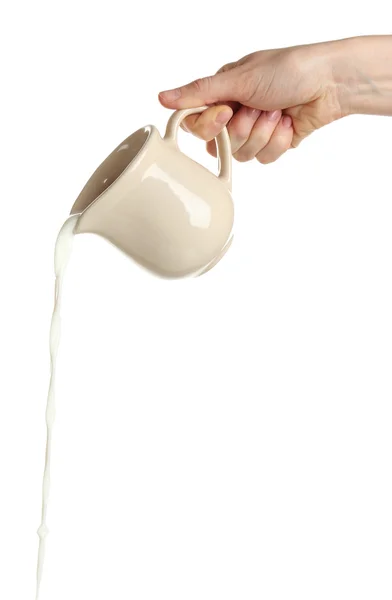 Выливание молока из кувшина, изолированного на белом — стоковое фото