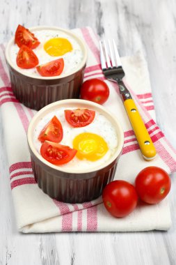 Baked eggs on wooden table close up