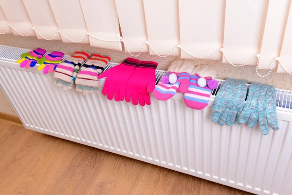 Luvas de malha secagem no radiador de aquecimento — Fotografia de Stock