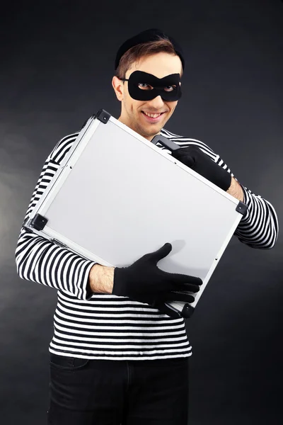 Thief with metal briefcase on dark background — Stock Photo, Image