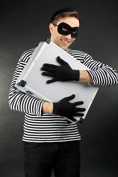 Thief with metal briefcase on dark background — Stock Photo, Image