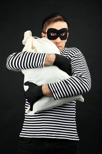 Ladrão com saco isolado em preto — Fotografia de Stock