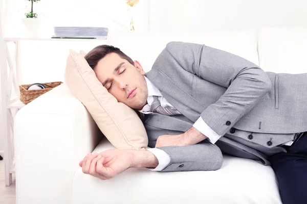 Elegante giovane uomo d'affari che dorme sul divano, a casa — Foto Stock