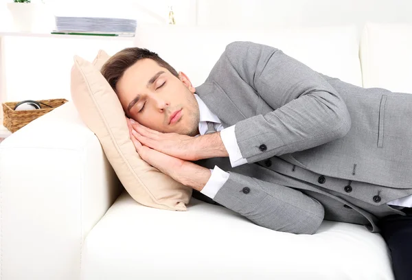 Κομψό νεαρό επιχειρηματία στον ύπνο στον καναπέ, στο σπίτι — Φωτογραφία Αρχείου