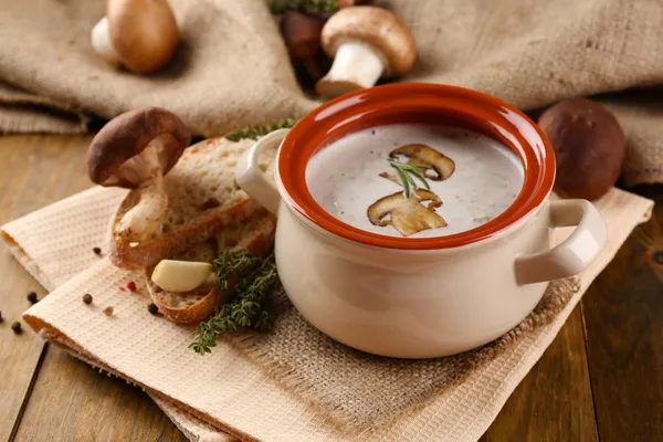 Sopa de cogumelos em panela, no fundo de madeira — Fotografia de Stock