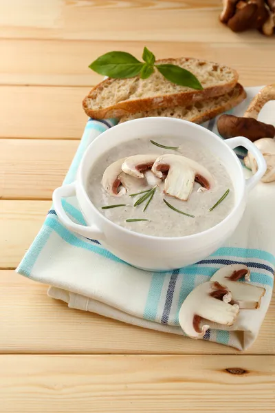 Sopa de cogumelos no pote, no guardanapo a cores, no fundo de madeira — Fotografia de Stock