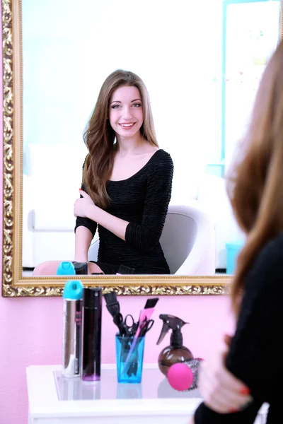 Young beautiful woman sitting front of mirror in room — Stock Photo, Image