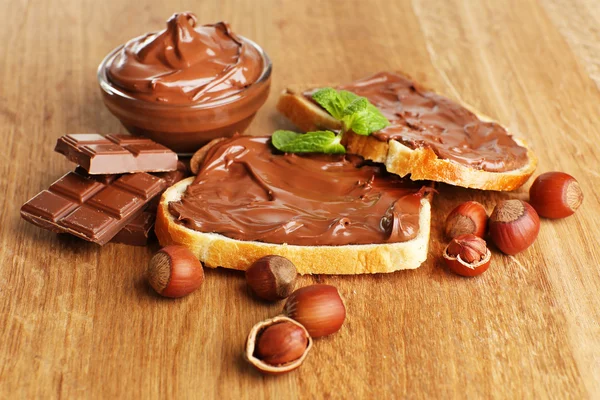 面包与甜巧克力榛子铺在木质的背景 — 图库照片