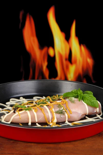 Filetes de pollo crudos en bandeja de goteo, sobre fondo de fuego —  Fotos de Stock