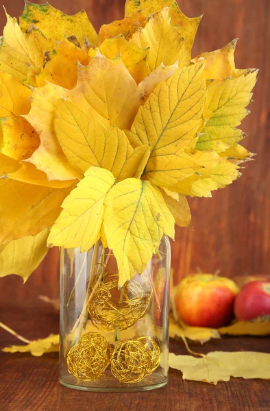 Feuilles d'automne lumineuses en vase sur table en bois close-up — Photo