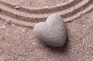 Gri zen stone kum arka plan üzerinde kalp şeklinde