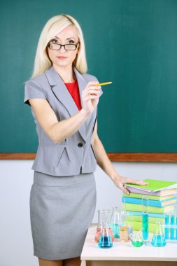 Tablo tüp tahta arka plan ile yakın duran kimya öğretmeni