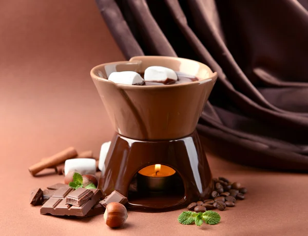 Schokoladenfondue mit Marshmallow-Bonbons auf braunem Hintergrund — Stockfoto