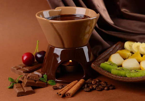 Fondue de chocolate con frutas, sobre fondo marrón —  Fotos de Stock