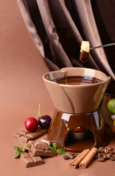 Chocolade fondue met fruit, op bruine achtergrond — Stockfoto
