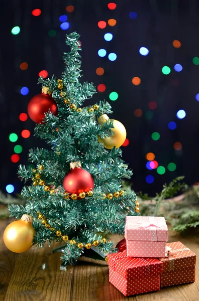 Dekorativa julgran med presenter på tabellen på ljus bakgrund Royaltyfria Stockbilder