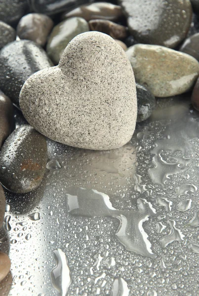 Pedra cinzenta em forma de coração, sobre fundo claro — Fotografia de Stock