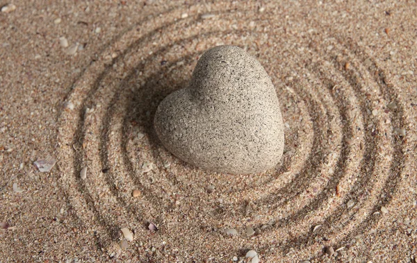 Pedra zen cinza em forma de coração, sobre fundo de areia — Fotografia de Stock