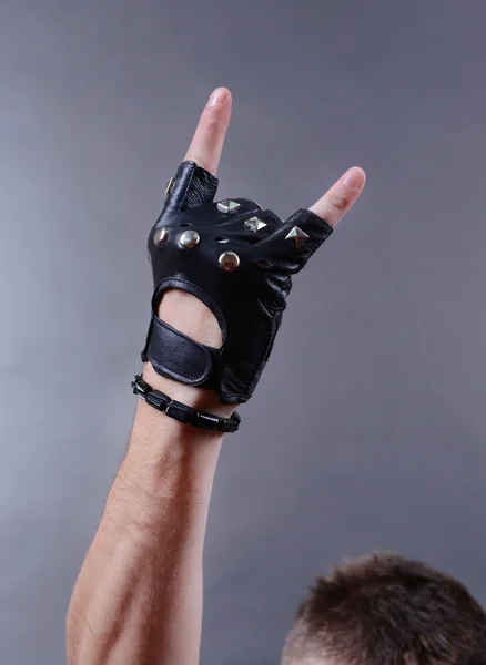 Χέρι του rocker στο βραχιόλι και δέρμα mitten, σε γκρι φόντο — Φωτογραφία Αρχείου