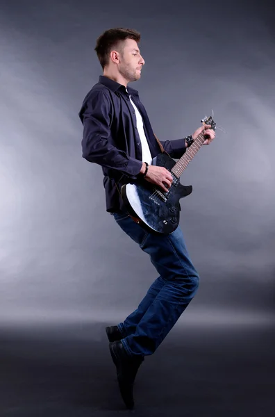 Young musician playing guitar, isolated on white — Stock Photo, Image