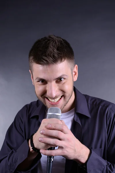 Joven músico cantando, sobre fondo gris —  Fotos de Stock