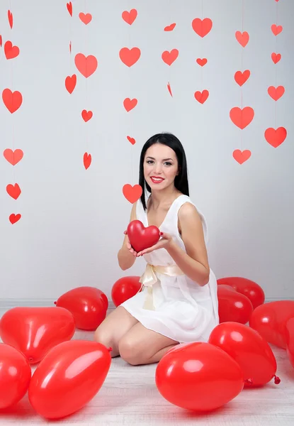 バレンタインの日に部屋で風船を持つ魅力的な若い女性 — ストック写真