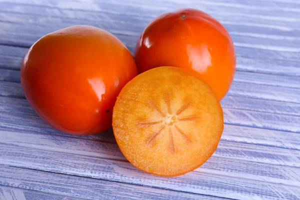 Ripe persimmons on wooden background — Stock Photo, Image