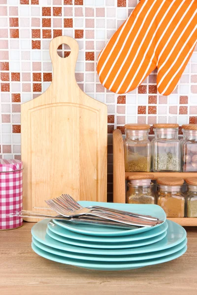 Platen in keuken op tafel op mozaïek tegels achtergrond — Stockfoto