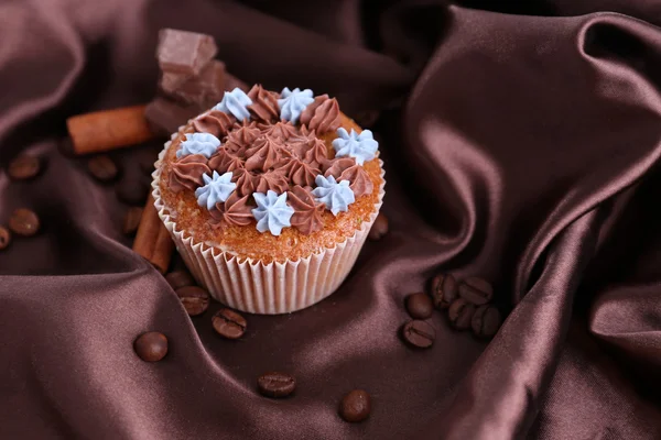 Leckere Cupcake mit Buttercreme, auf farbigem Stoff Hintergrund — Stockfoto