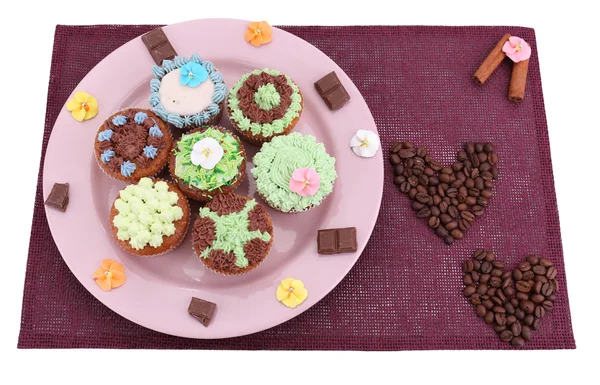 Sabrosos cupcakes con crema de mantequilla, en el plato, en la servilleta de color. aislado en blanco — Foto de Stock