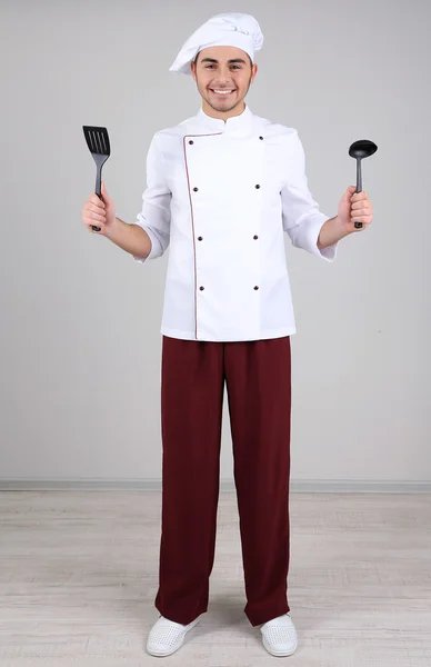 Profesionální kuchaři v bílých uniformách a klobouk, na šedém pozadí — Stock fotografie
