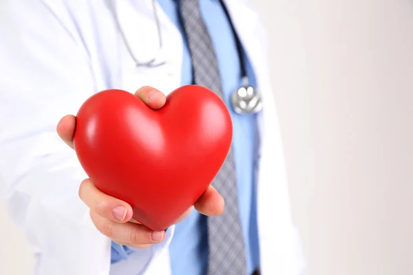Mężczyzna lekarz z czerwonym sercem w jego ręce, na białym tle — Zdjęcie stockowe