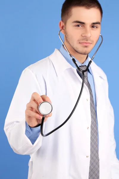 Médico masculino em pé no fundo azul — Fotografia de Stock