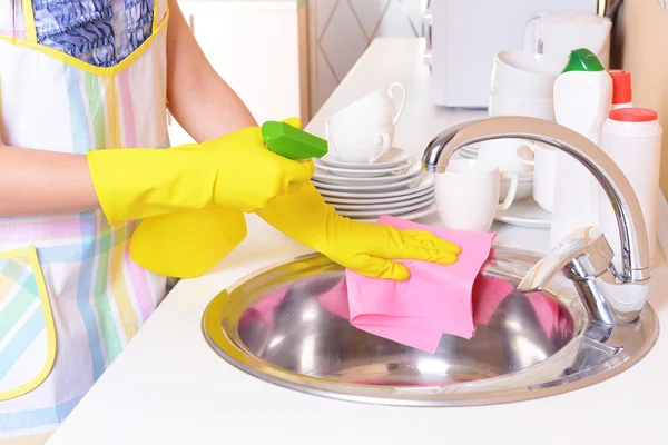 Piękna młoda kobieta czyści w kuchni — Zdjęcie stockowe