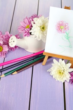 çiçek ve küçük şövale üzerinde ahşap masa yakın çekim resim ile kompozisyon