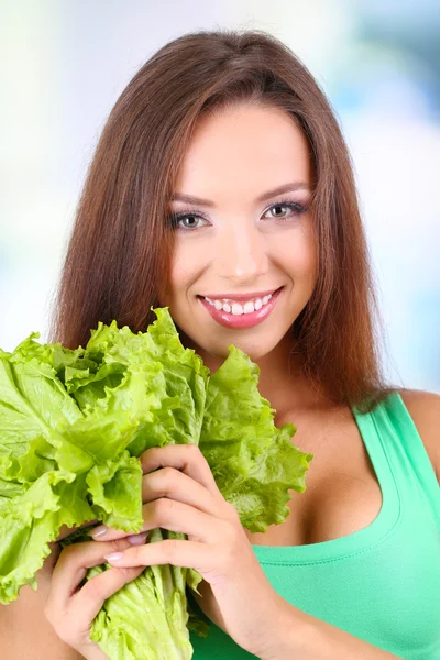 Beautiful girl with fresh salad on light background — Stock Photo, Image