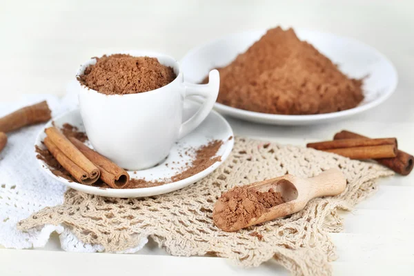 Poeder van de cacao in cup op servet op lichte achtergrond — Stockfoto