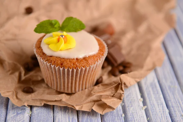 Tasty cupcake with butter cream, on color wooden table, on wooden background — Stock Photo, Image