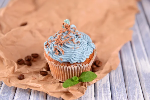 Tasty cupcake with butter cream, on color wooden background — Stock Photo, Image