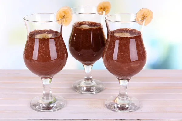 Cocktails with banana and chocolate on table on light background — Stock Photo, Image