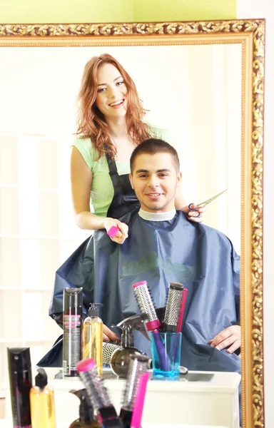 Красивая девушка парикмахер стрижка парень в салоне красоты — стоковое фото