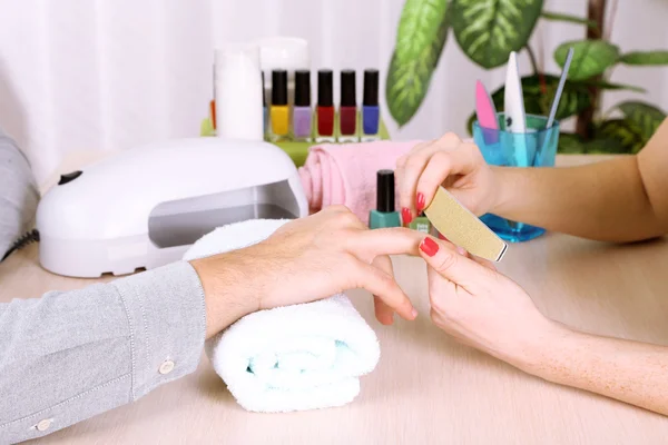 Meisje manicure doet manicure voor man in schoonheidssalon — Stockfoto