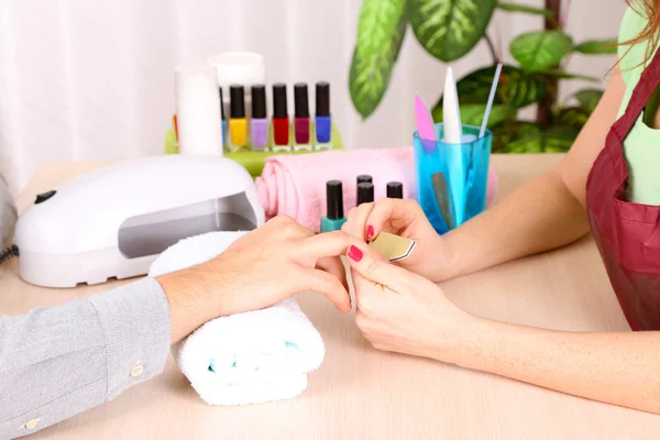 Girl manicurist doing manicure for man in beauty salon — Stock Photo, Image