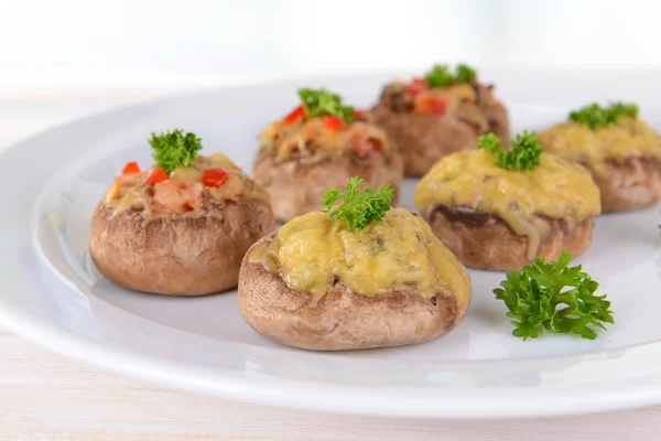 Stuffed mushrooms on plate on table on light background — Stock Photo, Image