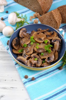 Masanın üzerinde tavada kızartılmış mantarlar.